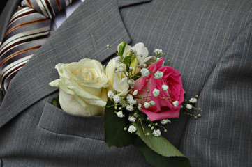 White and pink roses boutonniere on groom's wedding suit - obrazy, fototapety, plakaty
