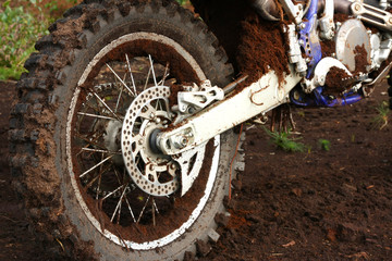 Close-up of muddy rear wheel of dirt bike, details