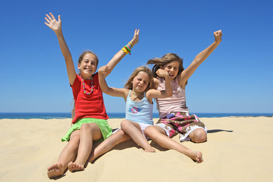 Trois enfants heureux et souriant sur la plage