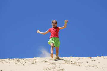 Jeune fille courant dans le sable