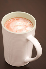 A single cup of foaming hot chocolate standing on a table