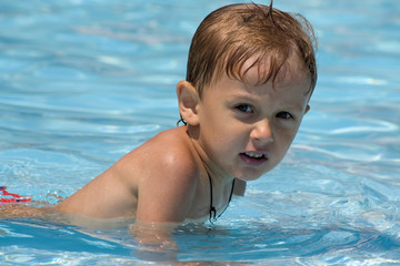 Fototapeta na wymiar portrait of little boy which lies in water on shoal