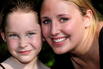 Young woman and child looking happy outdoors