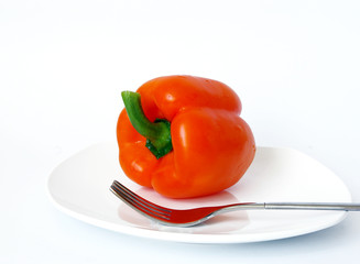 Sweet pepper and fork on a white plate