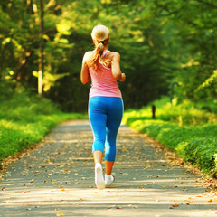 Pretty young girl runner in the forest.