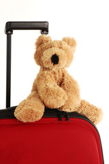 teddy bear toy on a red suitcase with long handle