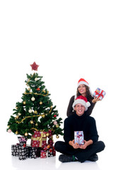 Christmas, happy couple next to Xmas tree wth presents,