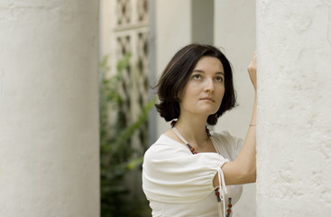 portrait of pretty woman standing near white column