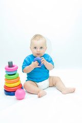 Fototapeta na wymiar cute baby boy playing with colorful toys