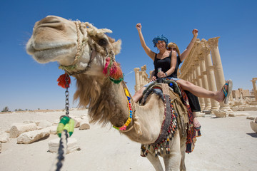 two girls are ride on camel in desert
