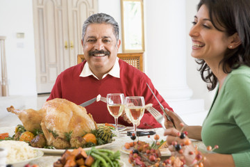 Father And His Adult Daughter Sitting Down For Christmas Dinner