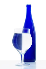 Glass with a blue bottle on a white background