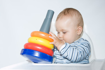 cute baby boy playing with colorful toys
