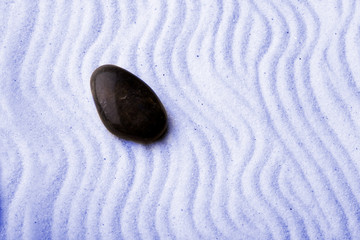 Fototapeta na wymiar Rock in a zen rock garden with blue sand