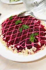 Plate of herring under a fur coat over wattled pad