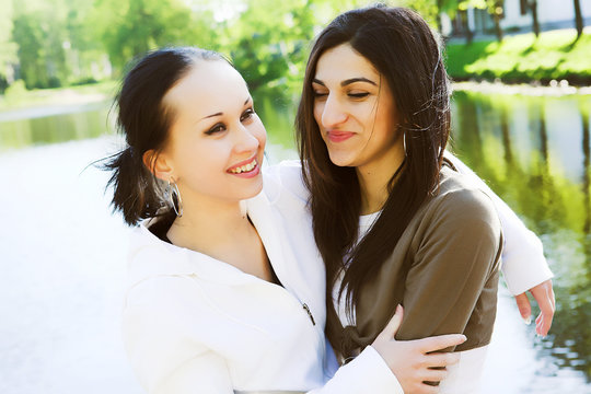 Two young women by the lake having fun..