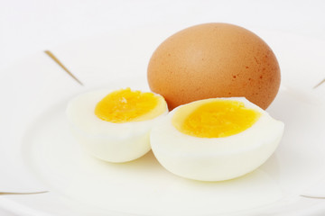Cooked egg slieced into half put together with raw egg.