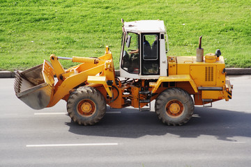 Yellow bulldozer on the road