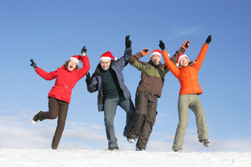 Friends with Santa hats dance on flank of hill