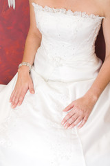 Close up of wedding dress, bride sitting down