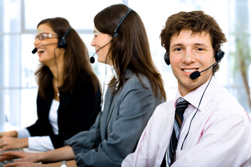 Customer service team working in headsets, smiling.