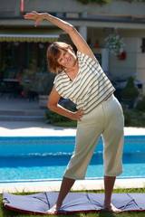 Happy active senior woman doing workout exercise at home