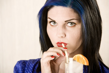 Pretty woman sipping cocktail through a bendable straw