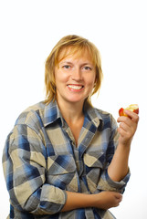 Middle-aged woman eating apple with a smile