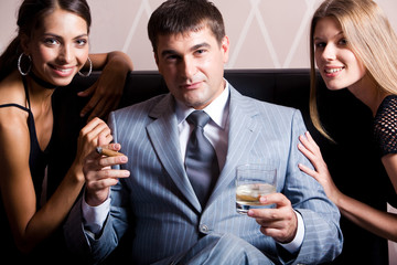 Portrait of handsome man in grey suit sitting with whisky