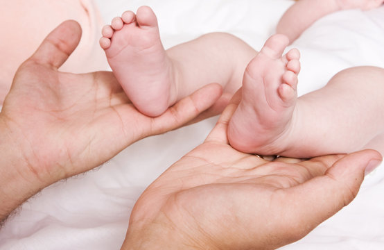 Little baby foots in hands of father