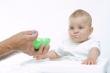 man feeding baby with a spoon, on bright background