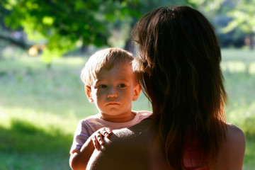baby looking over mother's shoulder