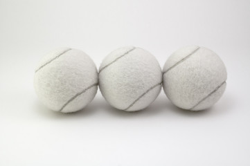 Tennis balls in a arranged in a row.