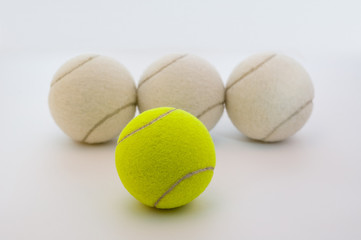 White tennis balls with yellow ball ion front.