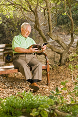 senior man reading on a bench