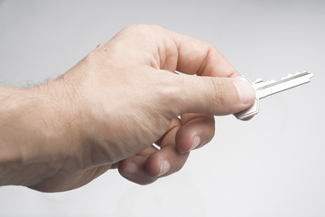 mano y llave aisladas sobre fondo blanco