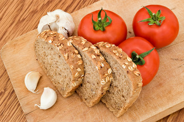 garlic bread slices and tomatoes on wood board