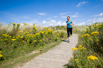 A young sporty woman running in the countryside