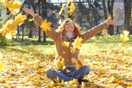 Happy Girl Throwing Autumn Leaves