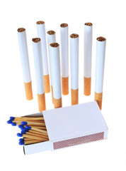 Cigarettes standing upright with matchbox isolated on white
