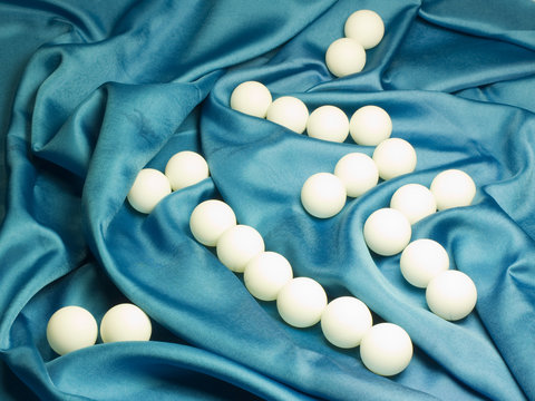 Ping pong balls on blue fabric