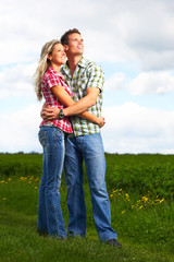 Young love couple smiling in the field.