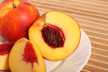 Nectarine fruit, a half and two quarters, on plate, close-up