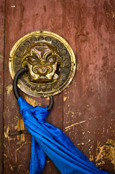 Ornate door handle and prayer scarf at monastery
