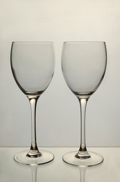 Two empty wine glasses on grey background