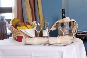 champagne glasses and bottle in hotel suite for celebration.