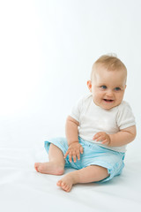Fototapeta premium cute laughing baby boy sitting on white background