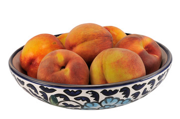 Peaches on hand painted plate, isolated on white.