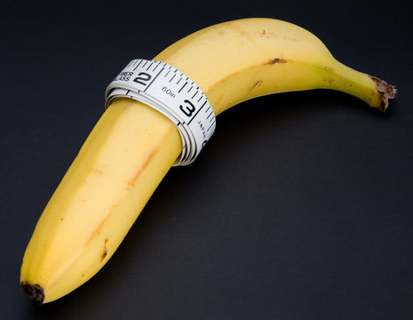 A banana with a tape measure wrapped around it isolated