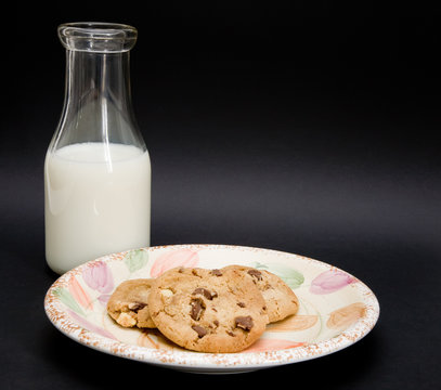 An old milk bottle and a plate of cookies isolated
